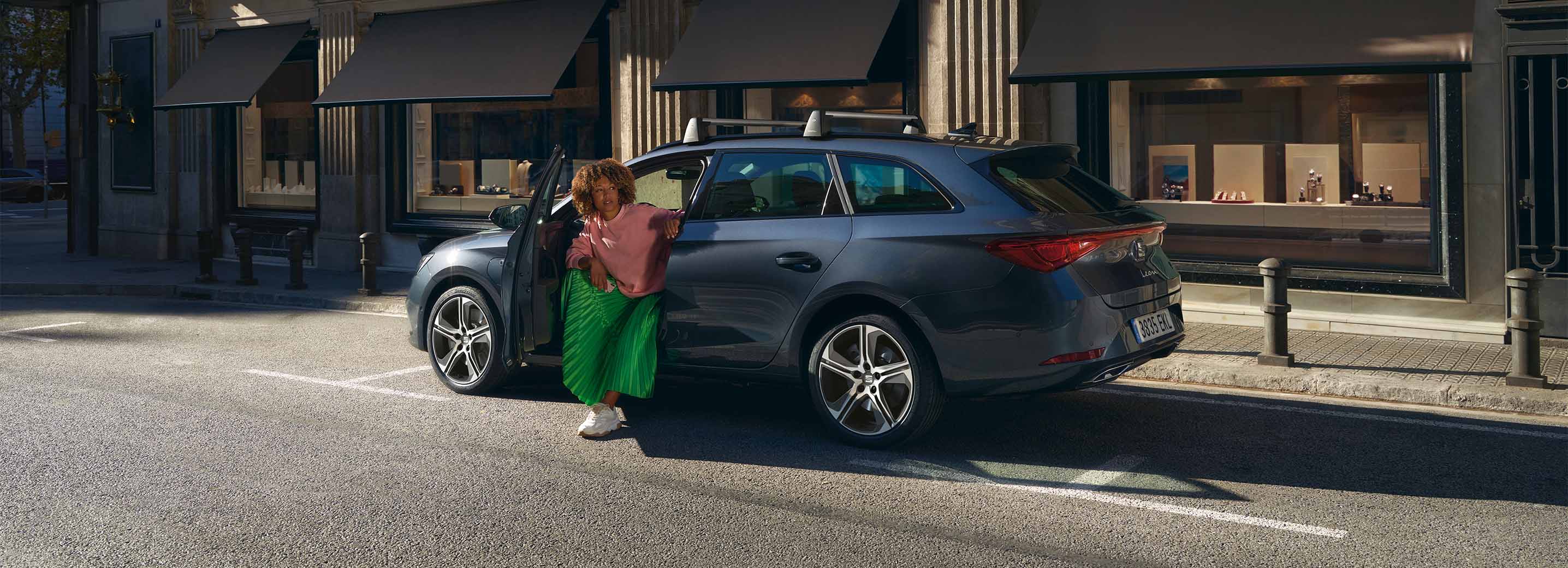 SEAT León aparcado en una calle de la ciudad con una persona saliendo del vehículo