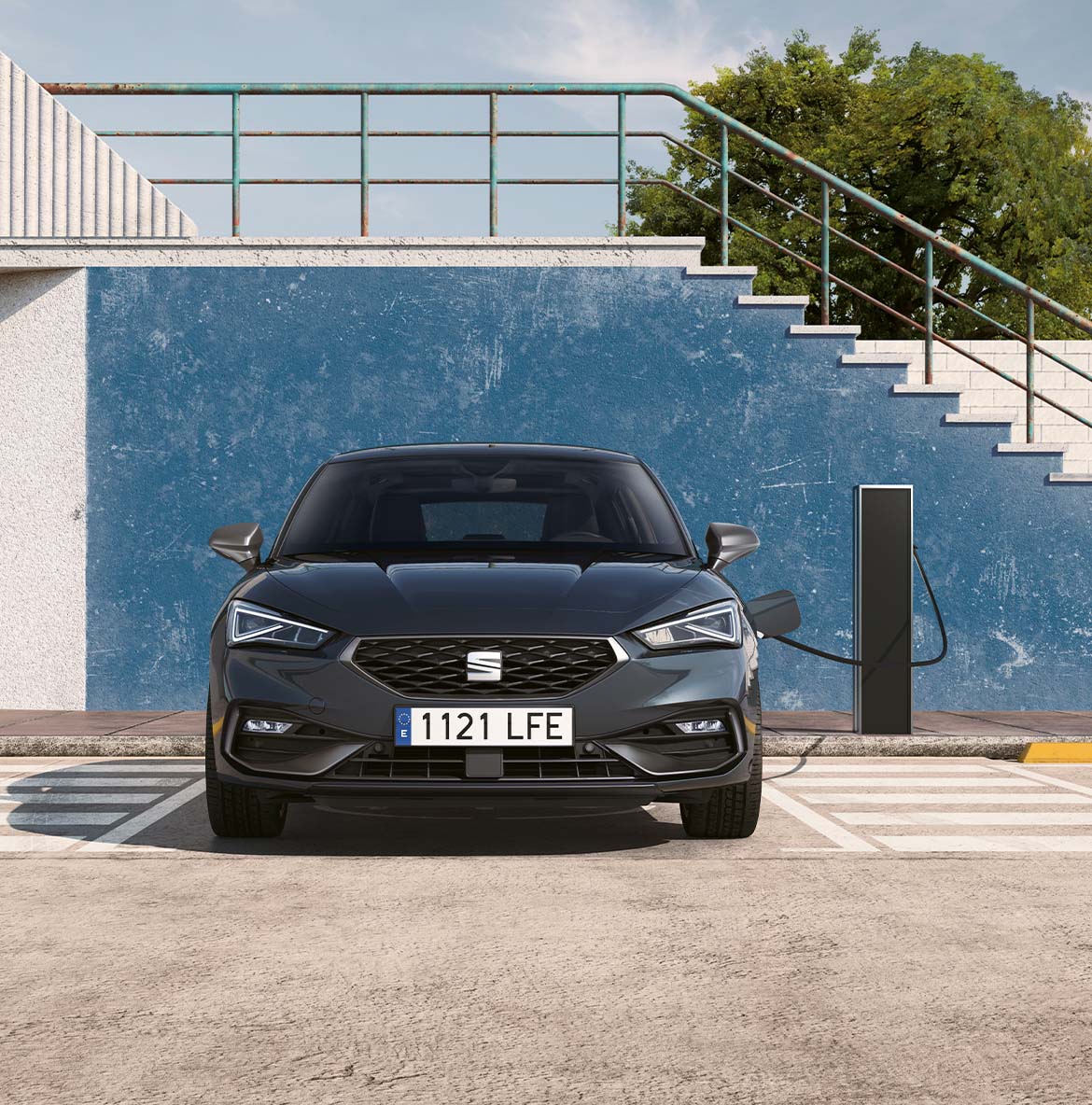 SEAT León vehículo eléctrico híbrido enchufable aparcado en una estación de carga bidireccional, como ejemplo de las capacidades avanzadas de carga híbrida