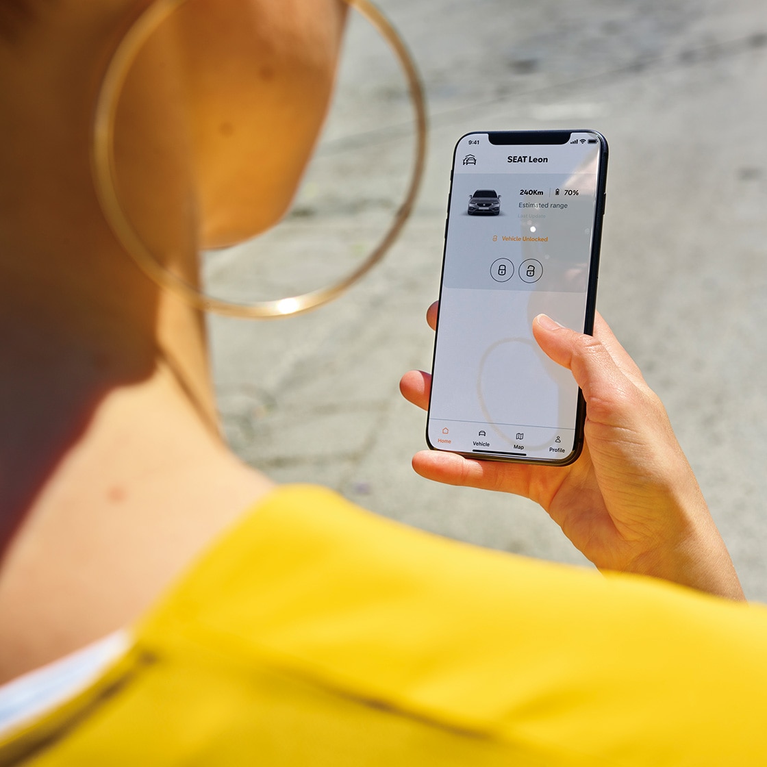 persona utilizando My SEAT App en un smartphone, se muestran las funciones de gestión y conectividad del vehículo