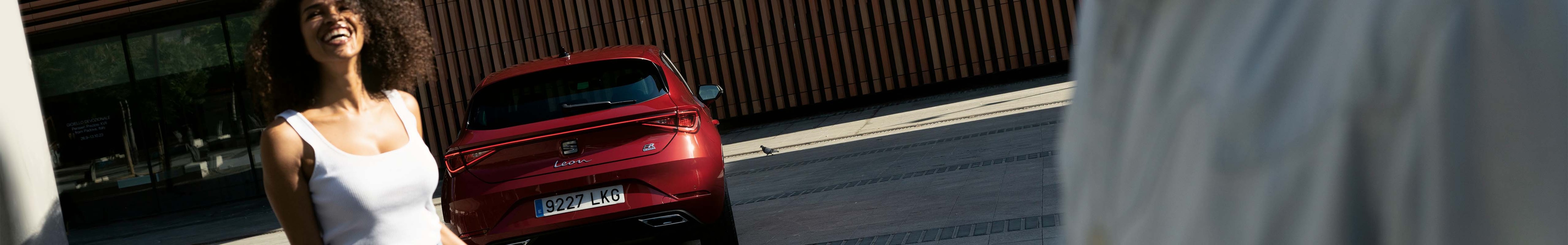 seat leon aparcado junto a una pareja, desmintiendo los prejuicios comunes sobre los coches híbridos eléctricos