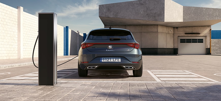 SEAT León phev en una estación de carga, como ejemplo de una guía completa de coches híbridos para conductores ecológicos